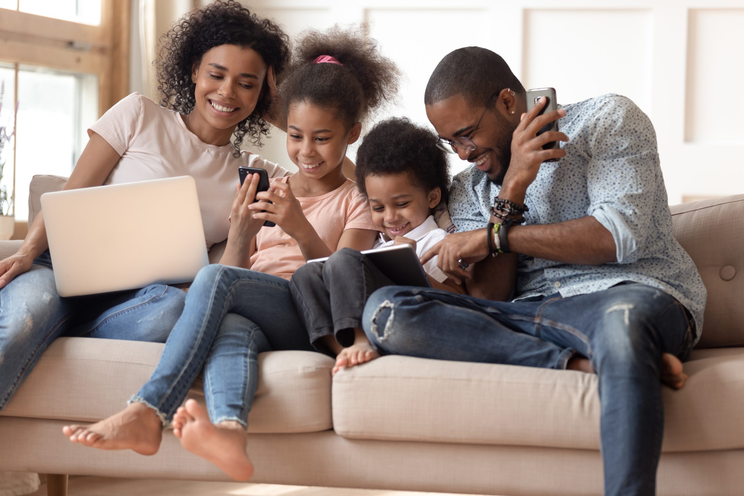 Famille sur canapé qui utilisent les objects connectés pour regarder Kunbix